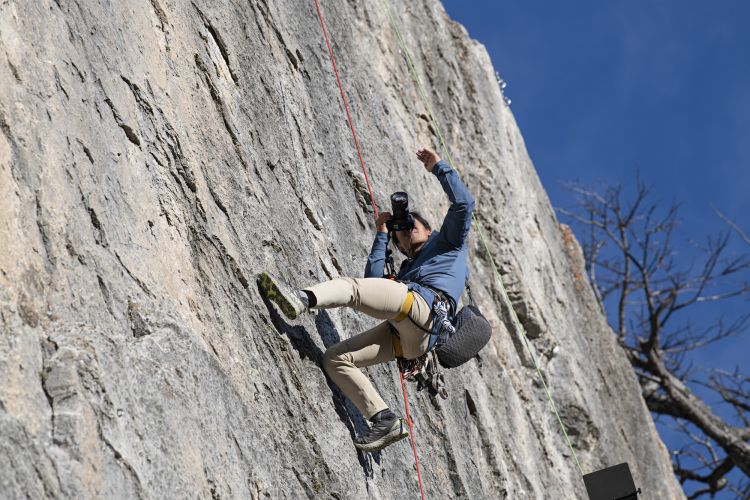 Jimmy Chin climbs a cliffside to capture a shot