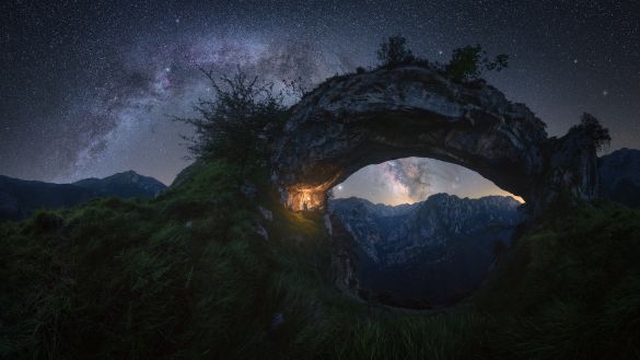 “Double Arch” – Pablo Ruiz García 

“Picos de Europa” – Spain

This spectacular arch-shaped rock formation is located in “La Hermida” gorge, in the Picos de Europa mountain range in Spain.

At first, my initial idea was to capture the galactic center inside the arch, but finally, I decided to shoot the two arches overlapped at this time of the year (late spring) when the Milky Way is still not too high in the sky.